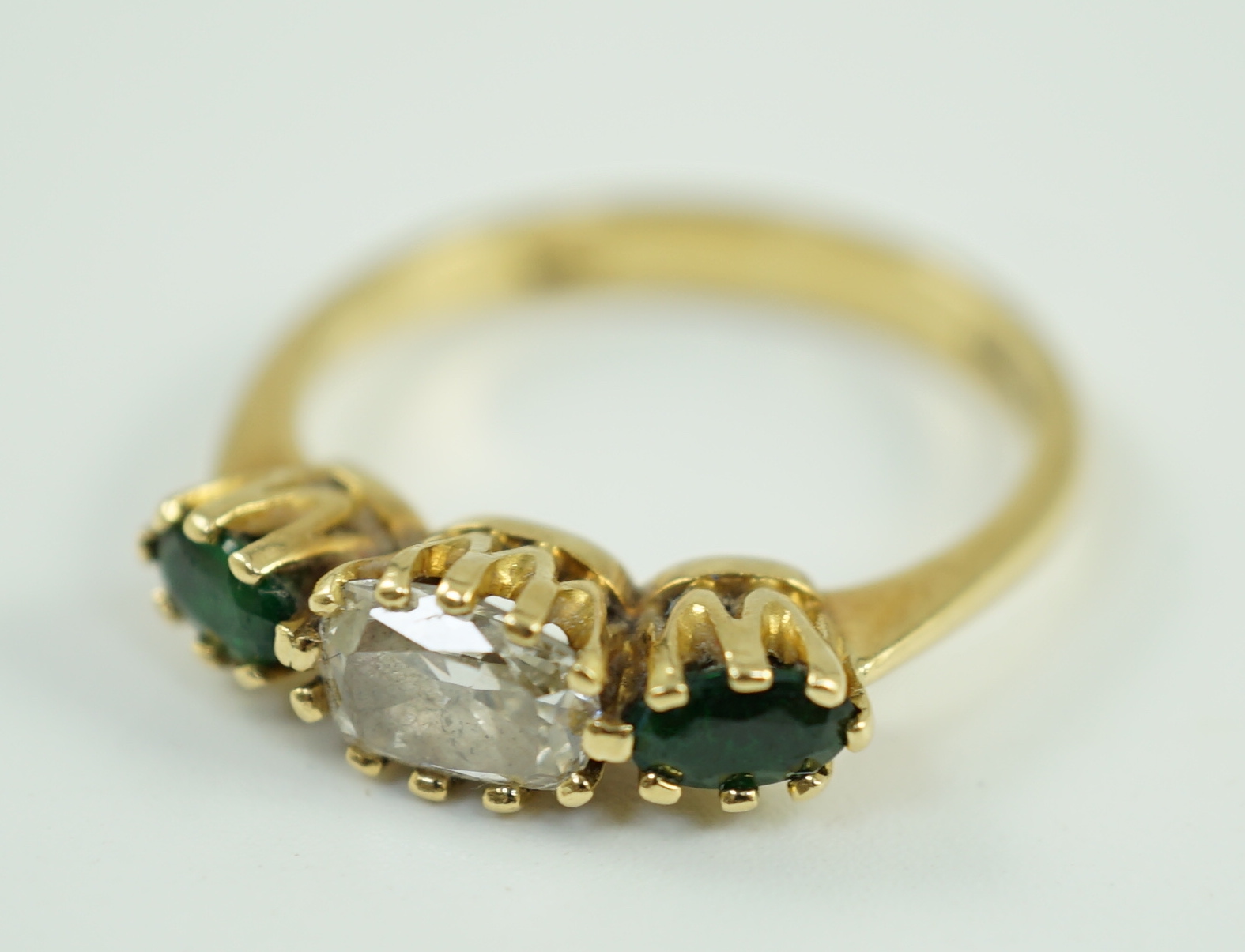A modern 18ct gold, diamond and green tourmaline set three stone ring